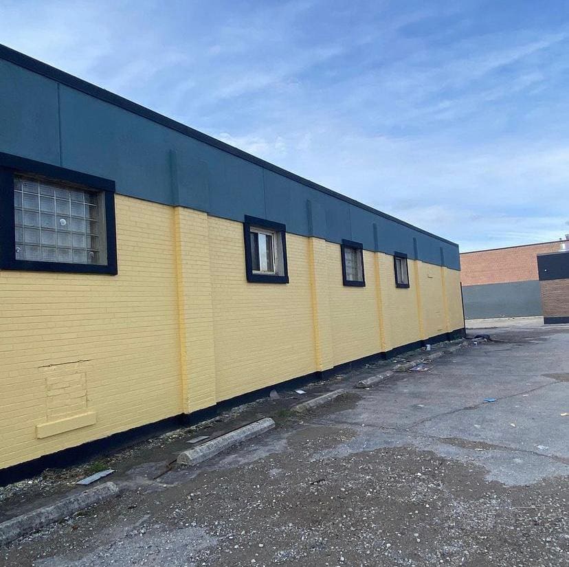 Exterior commercial repaint in yellow and navy blue
