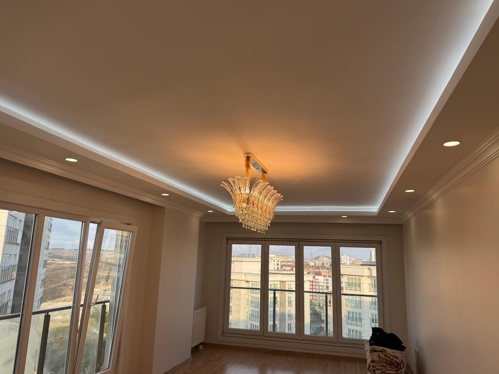 Renovated living room ceiling with crown molding and cove lighting
